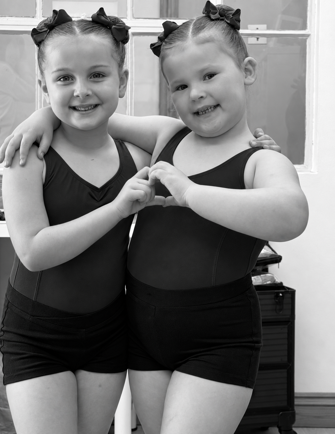 Two young LHTS dancers making a heart with their hands