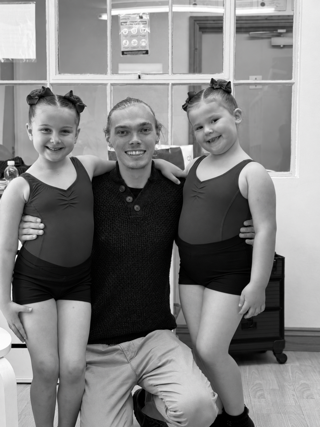 Joe smiling with two young LHTS dancers at the studios