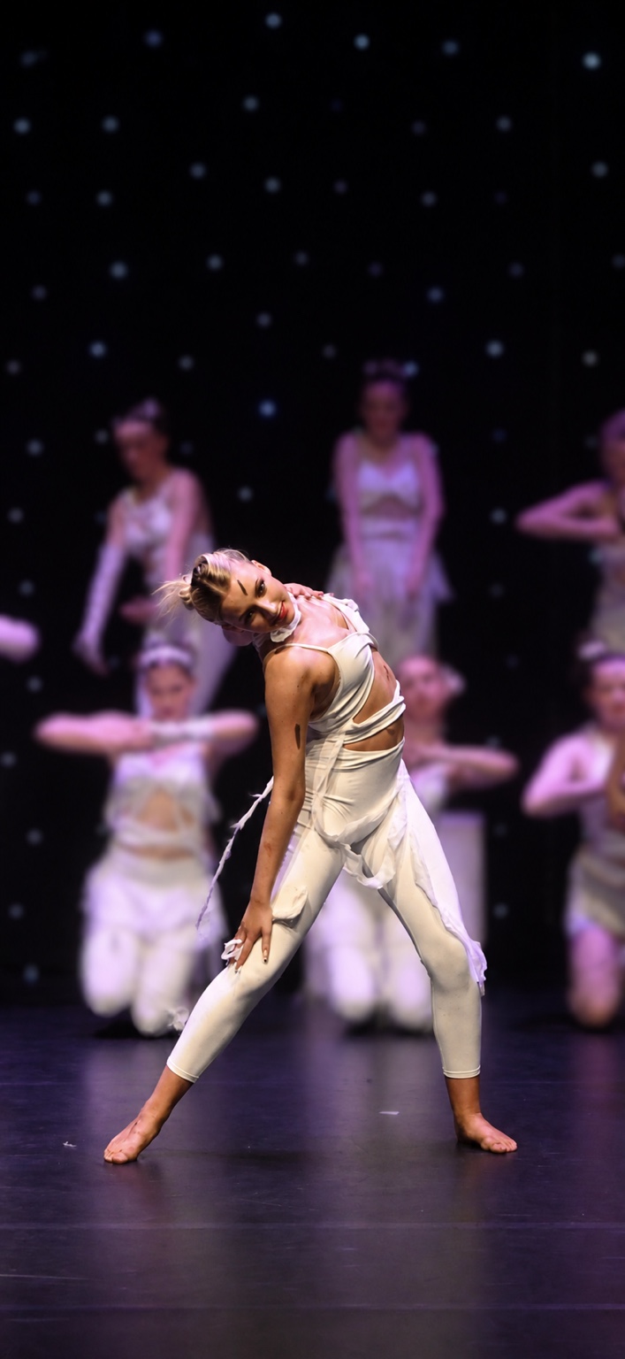 Nuala performing on stage, smiling as she dances